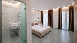 A modern hotel room with a marble bathroom, a large bed, and a view of the outdoors through the window. - Sun George (Himare)