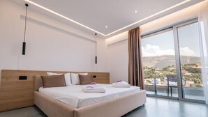 A modern bedroom with a large bed, a wooden headboard, and a view of the landscape through a large window. - Sun George (Himare)