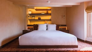 A large bed with white linens, wooden headboard, and bedside tables with lamps. - Hôtel Confidentiel (Paris)