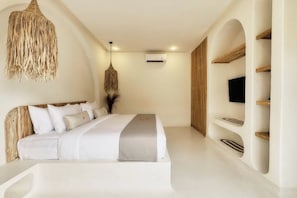 Een moderne slaapkamer met een bed, een hanglamp, ingebouwde planken en een airconditioner.