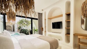 Een moderne slaapkamer met een groot bed, een televisie aan de muur en uitzicht op een zwembad en groen buiten.