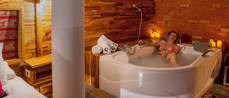 A large bathtub in a room with wooden walls and a tiled floor.
