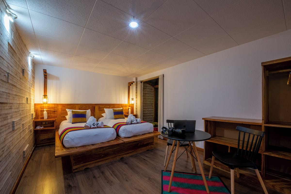 Una habitación de hotel con una cama de madera, un escritorio y una silla.