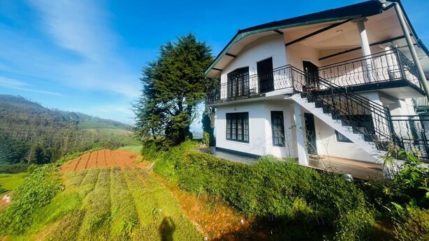 A two-story white building with a balcony and a staircase. - The Crowns Lodge (Nuwara Eliya)