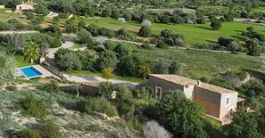 A residential property with a swimming pool, a small house, and a well-maintained garden.