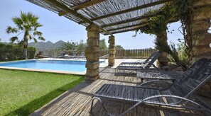 A pool area with lounge chairs and a pergola structure. - Stunning Finca with Heated Pool for 8 Guests (Illes Balears)