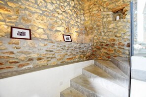 A stone wall with framed pictures and a staircase. - Stunning Finca with Heated Pool for 8 Guests (Illes Balears)