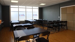A conference room with tables, chairs, and a view of the outside through large windows. - Blue Viking Studios (Reykjanesbær)