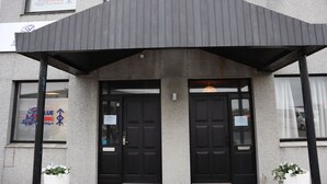 A building with a covered entrance, two black doors, and signage for 'Blue Viking.' - Blue Viking Studios (Reykjanesbær)