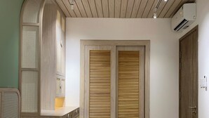 A bedroom with a bed, a wardrobe, and a built-in shelf. - An Corner - Sora Garden II Apartment (Ho Chi Minh City)