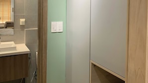 A bathroom with a wooden vanity, a mirror, and a recessed shelf. - An Corner - Sora Garden II Apartment (Ho Chi Minh City)