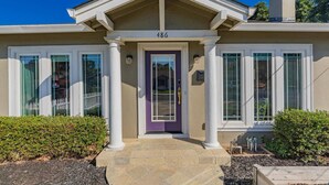 A two-story house with a beige facade, white trim, and a purple door. - Charming Craftsman in Downtown SJ (San Jose)