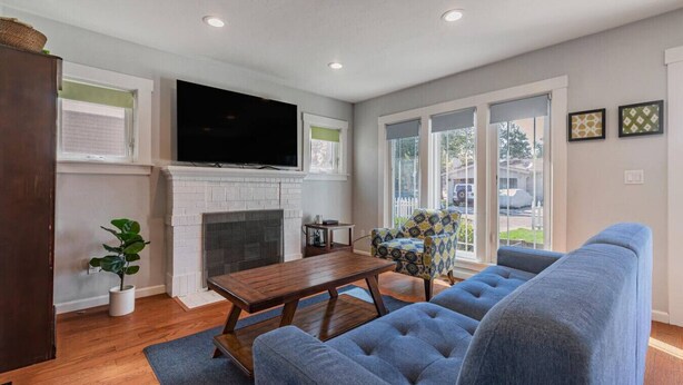 A living room with a fireplace, a television, and a sofa. - Charming Craftsman in Downtown SJ (San Jose)