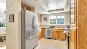 A modern kitchen with wooden cabinets, stainless steel appliances, and a large window providing natural light. - Tranquil 3BDR/2BA Fremont Escape (Fremont)