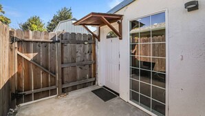 A garage with a wooden gate, a covered entryway, and a large window.