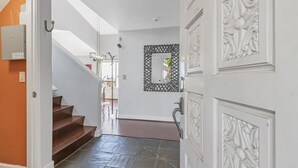 A hallway with a staircase, a decorative mirror, and a door with intricate paneling. - 4BR3.5BA w/Epic SJ Valley Views! (San Jose)