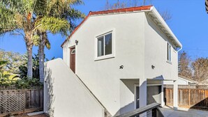 A two-story house with a red roof, a small window, and a door. - Downtown 1bd/1ba ADU (Sunnyvale)