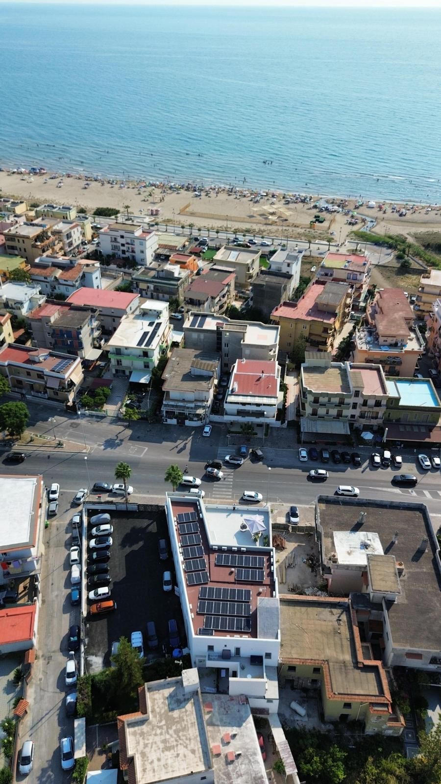 Ein Luftbild einer Küstenstadt mit Häusern, Straßen und einem Strand.