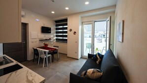Un espace de vie compact comprenant une cuisine, un coin repas et un canapé.