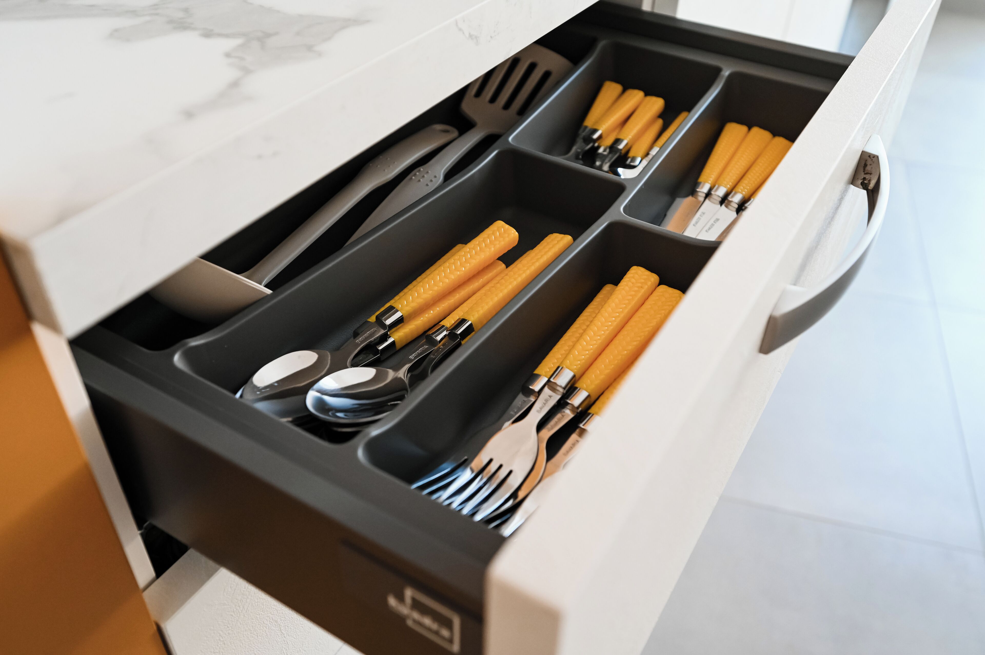 A kitchen drawer with utensils and cookware.