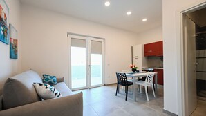 Un appartement moderne comprenant un espace de vie, un coin repas et une cuisine.