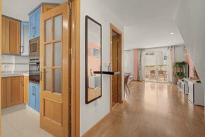 Cuina moderna amb armaris de fusta, un microones i una finestra gran.