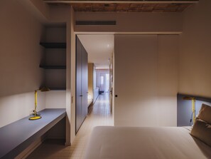 A hotel room with a bed, a desk, a chair, a wardrobe, and a staircase. - Casa Flor Nest Boutique Mid-term Barcelona (Barcelona)