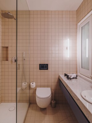 A bathroom with a shower, toilet, and sink.