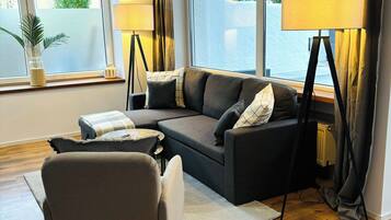 Deluxe appartement, 1 queensize bed met slaapbank, niet-roken, huisdieren toegestaan | Woonruimte | Een 55-inch flatscreentelevisie met satellietzenders