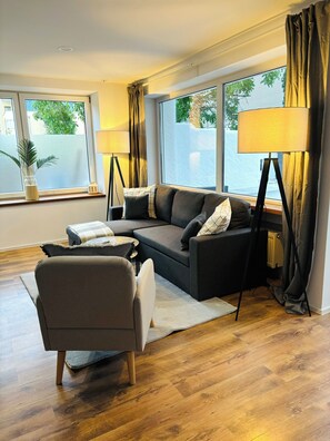 Deluxe appartement, 1 queensize bed met slaapbank, niet-roken, huisdieren toegestaan | Woonruimte | Een 55-inch flatscreentelevisie met satellietzenders