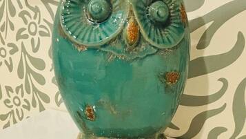 Een turquoise keramieken uilbeeldje met een gestructureerde basis, voor een achtergrond met patroon.