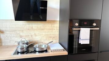 Deluxe appartement, 2 slaapkamers, niet-roken, keuken | Privékeuken | Een koelkast met diepvriezer, een oven, een kookplaat, een vaatwasser