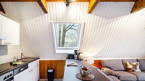 A modern kitchen with a built-in oven, a coffee maker, and a window with a view of trees. - Holiday Home 'Twistesee 42' (Bad Arolsen)