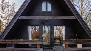 A triangular wooden cabin with a front door, two windows, and a deck. - Holiday Home 'Twistesee 42' (Bad Arolsen)