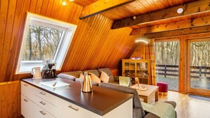 A cozy cabin interior with a wooden ceiling, a kitchenette, a sofa, and a dining area. - Holiday Home 'Twistesee 36' (Bad Arolsen)