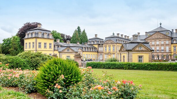 A large, multi-story building with a symmetrical facade, surrounded by well-maintained gardens and a clear sky. - Holiday Home 'Twistesee 36' (Bad Arolsen)