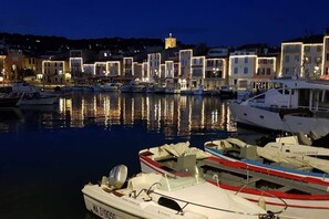 A marina at dusk with boats docked, reflecting buildings in the background. - Chez Giulia Cassis - Studio Near the Beach (Cassis)