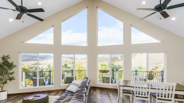 A spacious living room with a high ceiling, large windows, and a view of the countryside. - Lava`s Red King of The Hill (Lava Hot Springs)