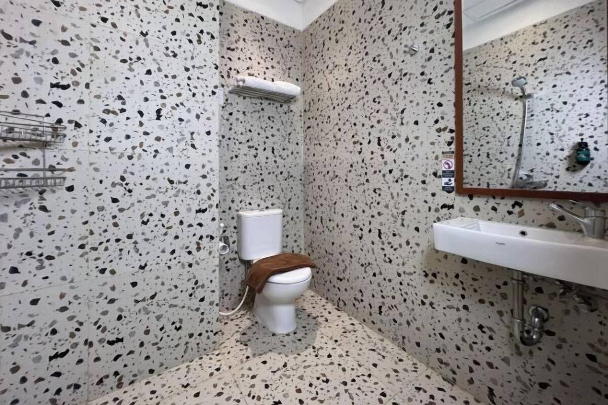 Une salle de bain avec des toilettes blanches, une douche et un lavabo.