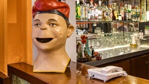 A bar area with a wooden counter, a telephone, and a variety of bottles and glasses. - Bed and Breakfast 'Single Room 1' with Balcony, Wi-Fi and Air Conditioning (figueres)