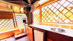 A compact kitchen with a sink, dishwasher, and wooden cabinets. - Bilocale Lu Liciu H10 in Centro (San Teodoro)