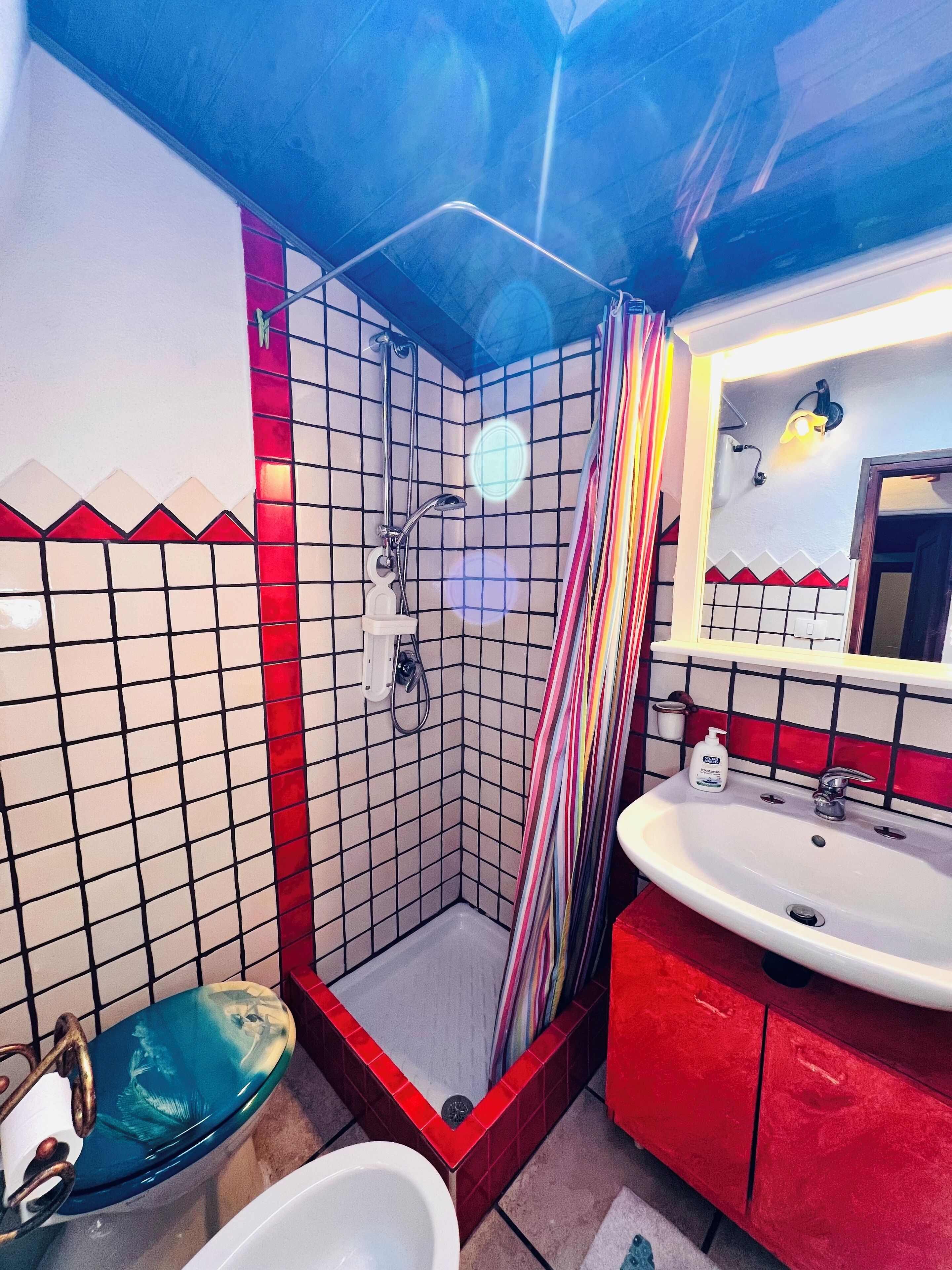 A bathroom with a shower, a sink, and a toilet.