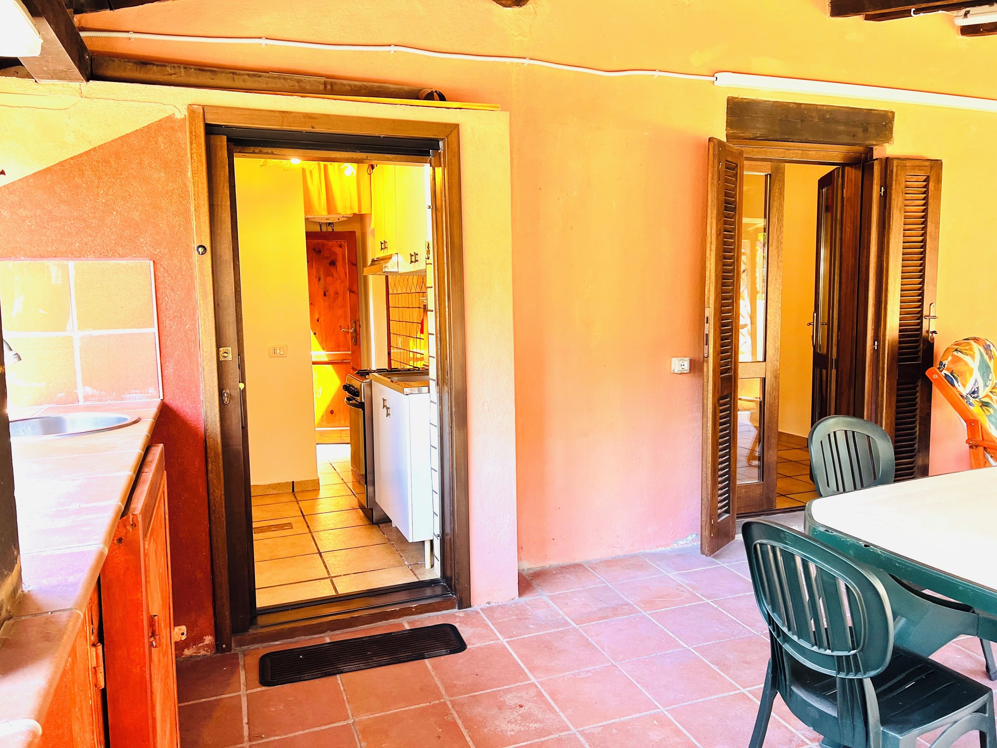 A compact kitchen with a tiled backsplash, a built-in oven, and a sink.