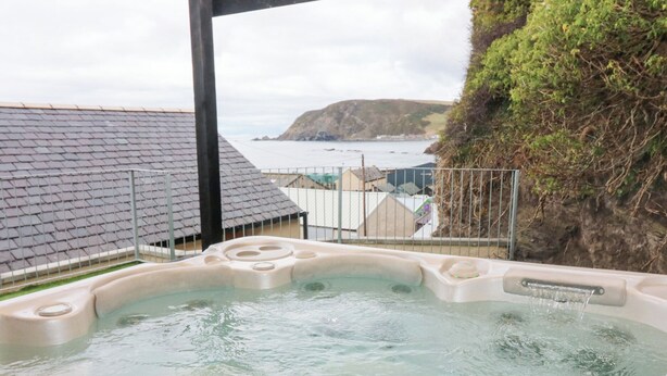 A hot tub with a view of the sea and a cliff. - The Old Kipper Hoose (Banff)