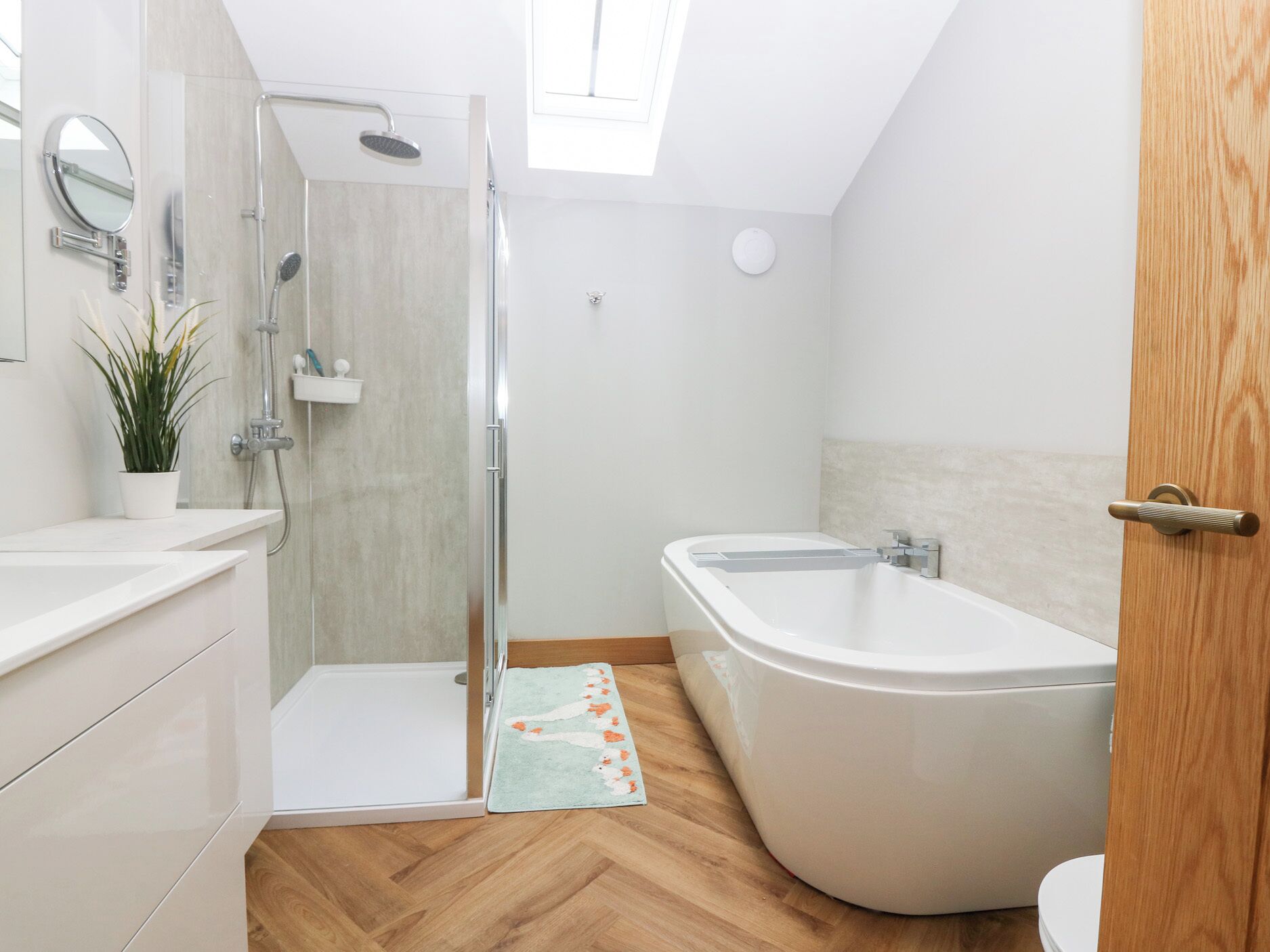 A modern bathroom with a walk-in shower, a freestanding bathtub, and a toilet.