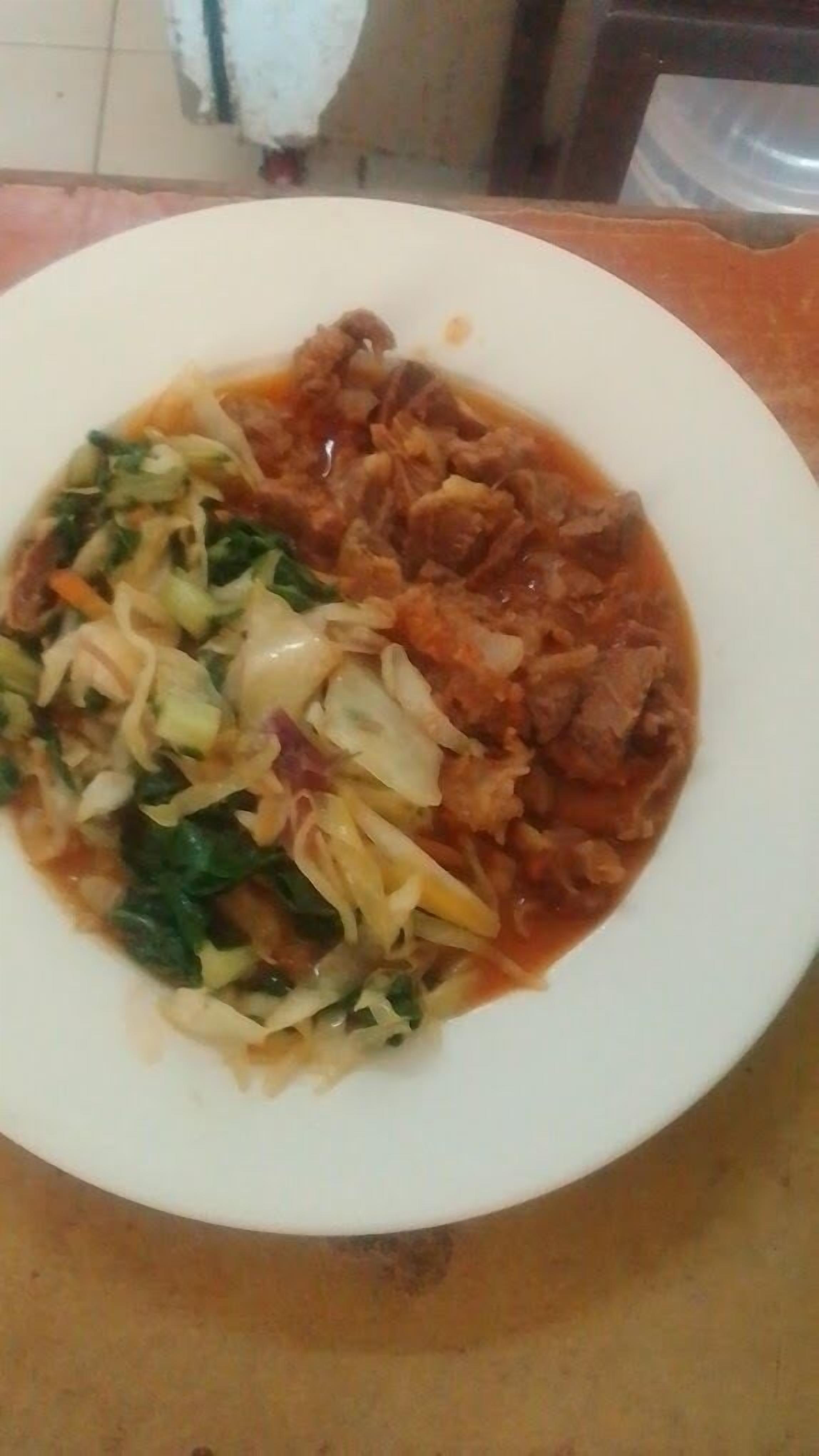 A plate of food with a variety of vegetables and meat, served on a white plate.