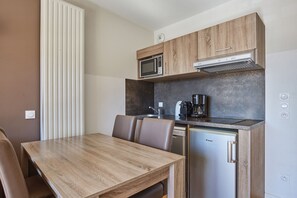 A compact kitchenette with a microwave, coffee maker, and dishwasher. - Residence Odalys Aquisana (La Salle-les-Alpes)