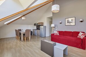 A modern loft apartment with a dining area, kitchen, and living space. - Residence Odalys Aquisana (La Salle-les-Alpes)
