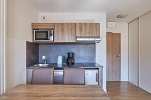 A compact kitchen with a microwave, coffee maker, and dishwasher. - Residence Odalys Aquisana (La Salle-les-Alpes)