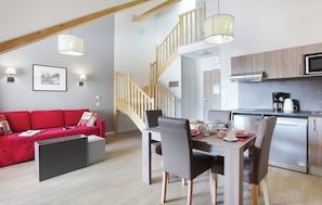 A modern kitchen with a built-in microwave, a coffee maker, and a refrigerator.